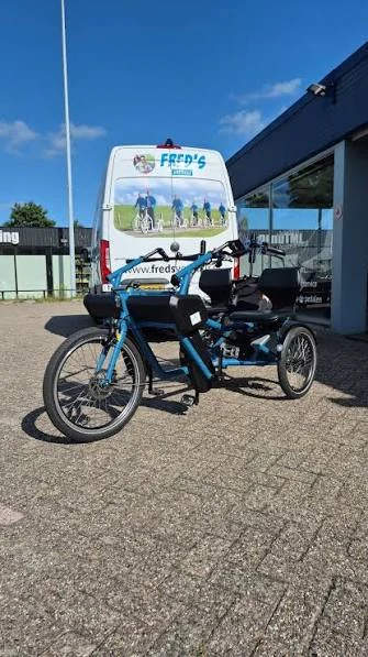 Blaues Doppelsitzer-Rad vor dem Bus von Fred’s Verhuur