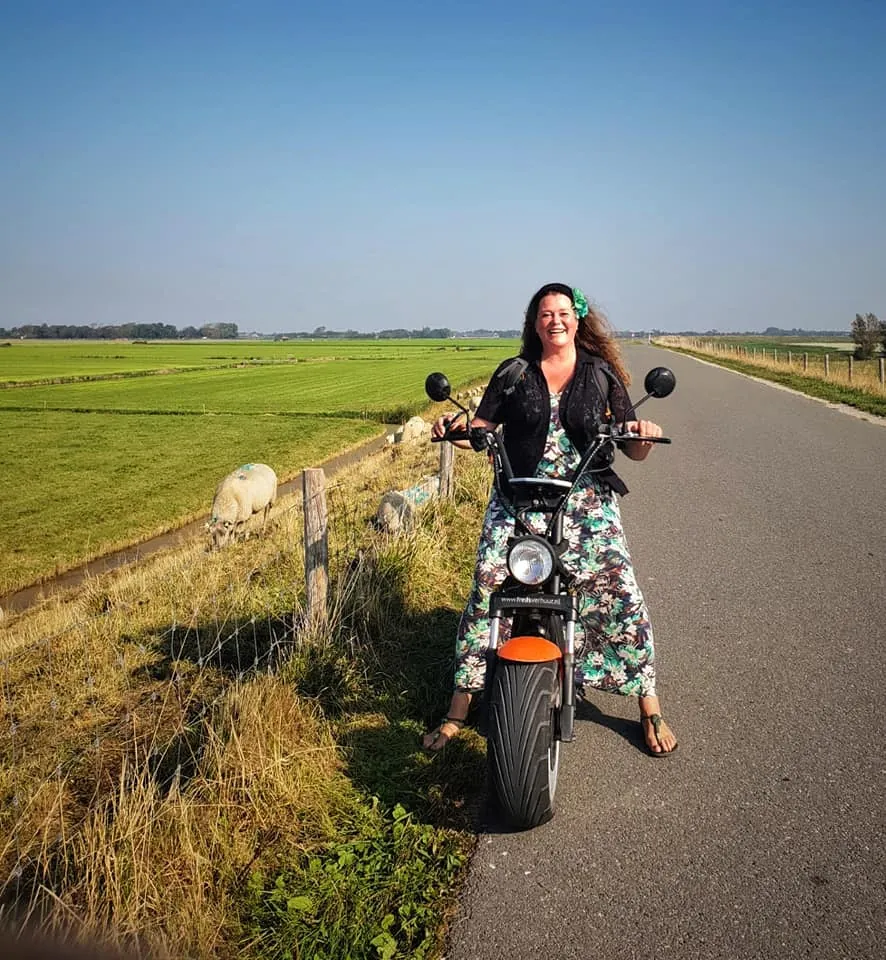 Woman on an E-Chopper on a polder road near Schagen