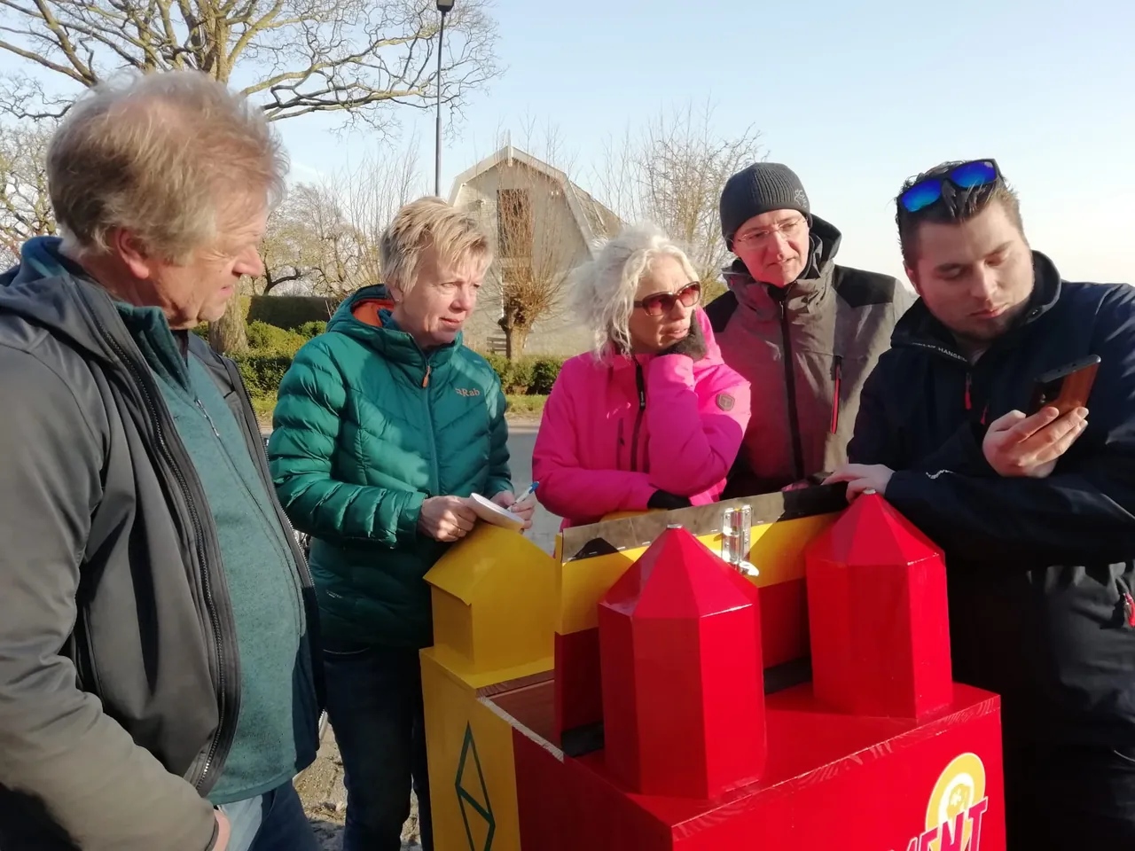 Groep lost samen een puzzel op bij de puzzelkar